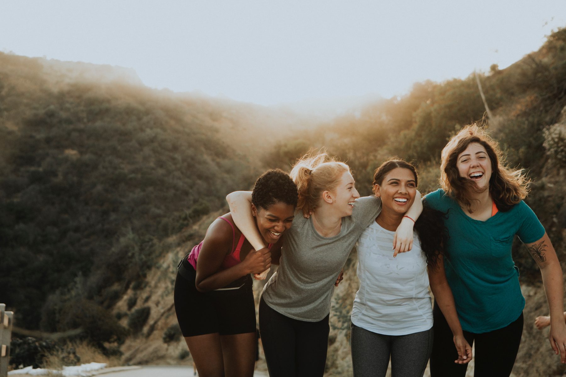 A group of smiling women standing together outside.