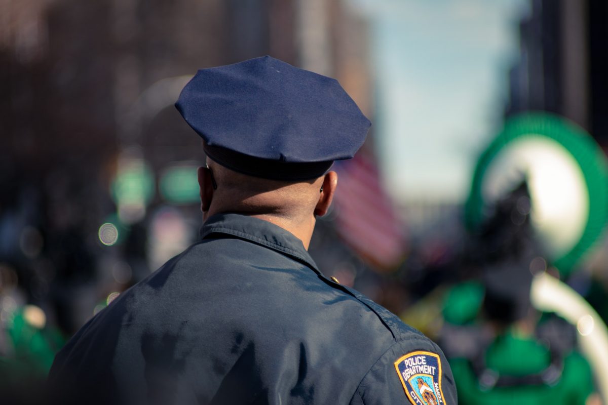 Police officer faces away to a faded background