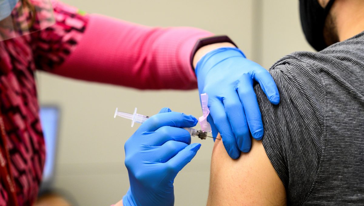 Nurse administers COVID-19 vaccine.