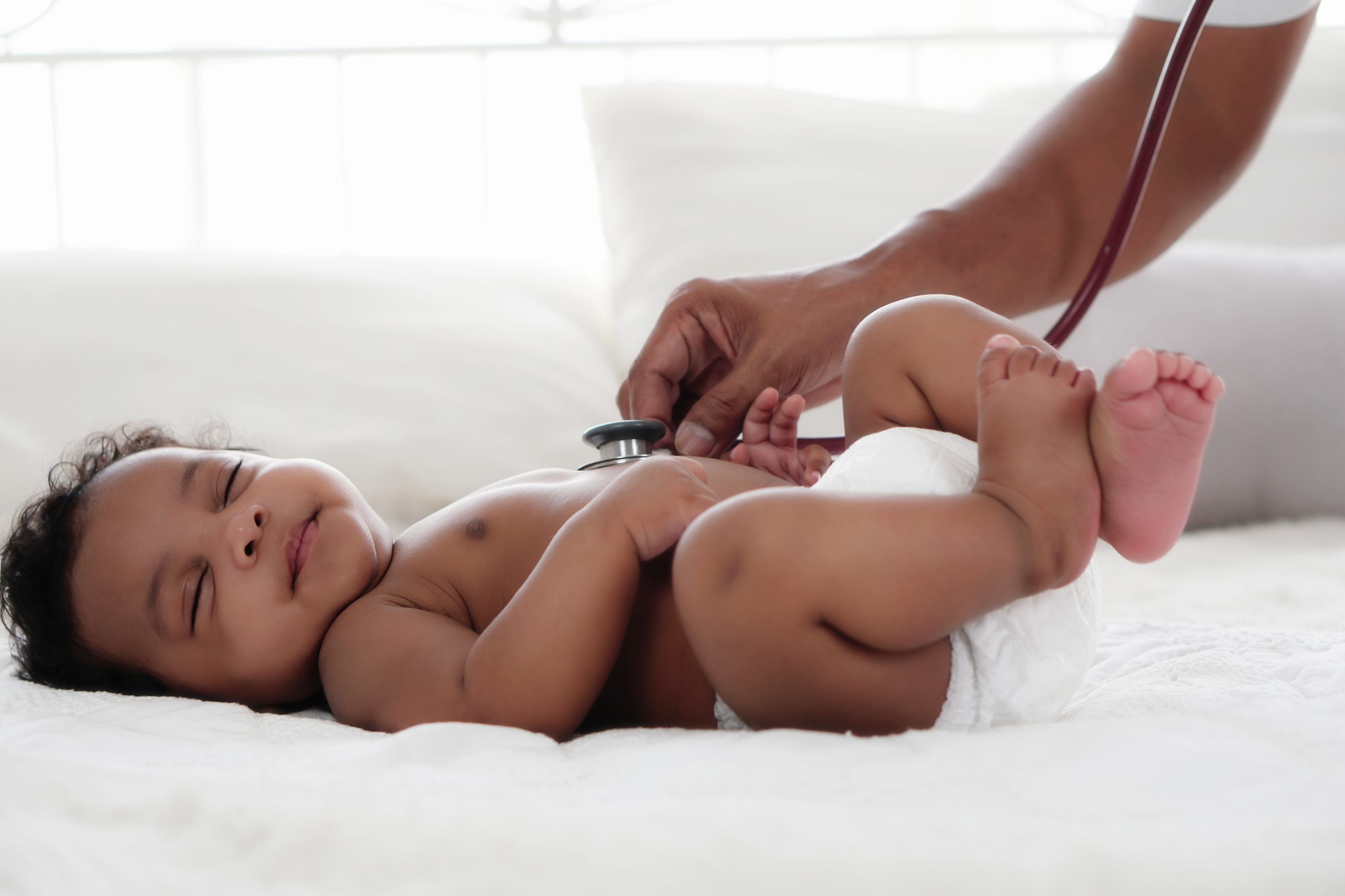 A baby having it's heart rate checked with a stethoscope 