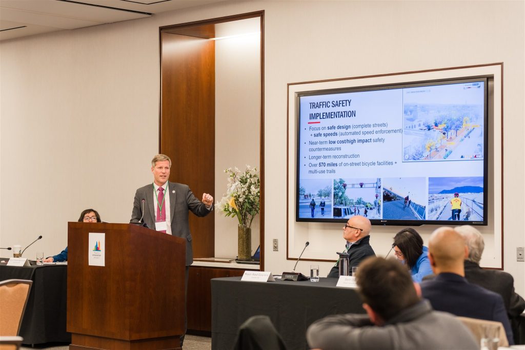 Mayor Tim Keller presents at a podium.