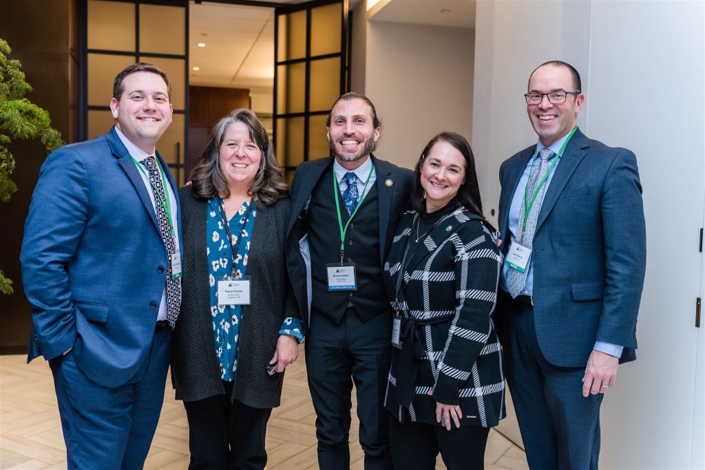 A group of conference attendees standing together and smiling.