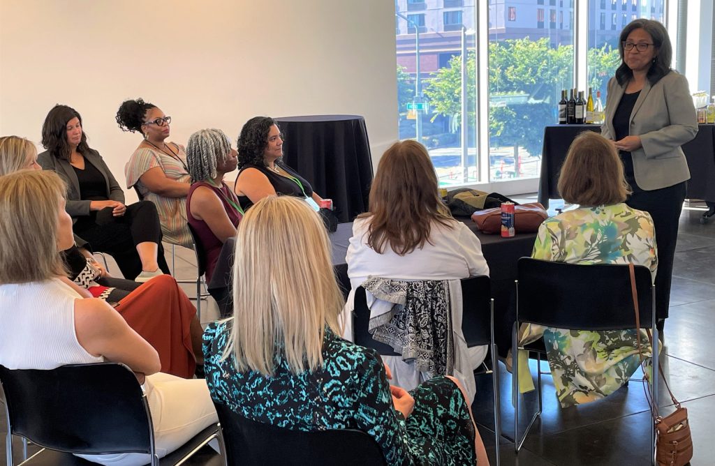 A group of women mayors sit and listen to a presentation.