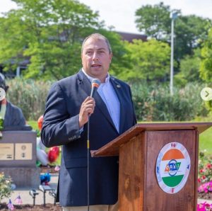 Supervisor Brian Kulpa speaks at a wooden podium with a microphone in his hand.
