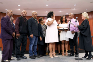 Mayor Chasity Wells-Armstrong being sworn in by a woman in judicial robes, surrounded by a small crowd.