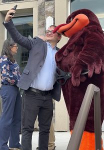 Then-Vice Mayor Michael Sutphin (Blacksburg, VA) snapping a photo with the HokieBird, Virginia Tech’s mascot, at a ribbon cutting in 2025.